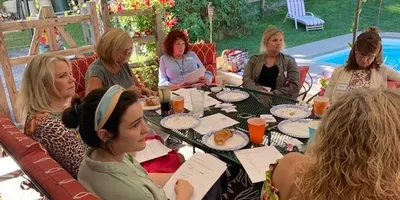 A group of people sitting at a table with plates.