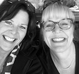 Two women smiling for a picture in black and white.